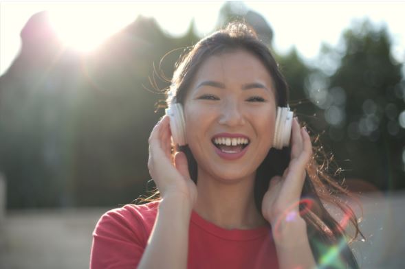 Smiling girl in red crew neck shirt with headphones